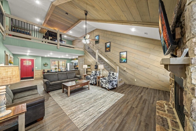 living room featuring hardwood / wood-style floors, wood walls, wooden ceiling, high vaulted ceiling, and ceiling fan