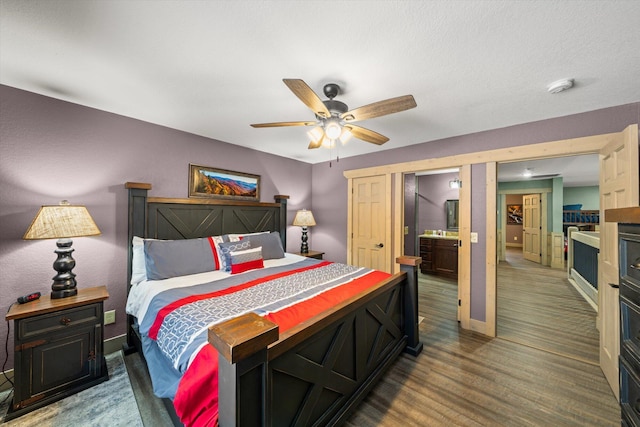 bedroom with ceiling fan, ensuite bathroom, and wood-type flooring