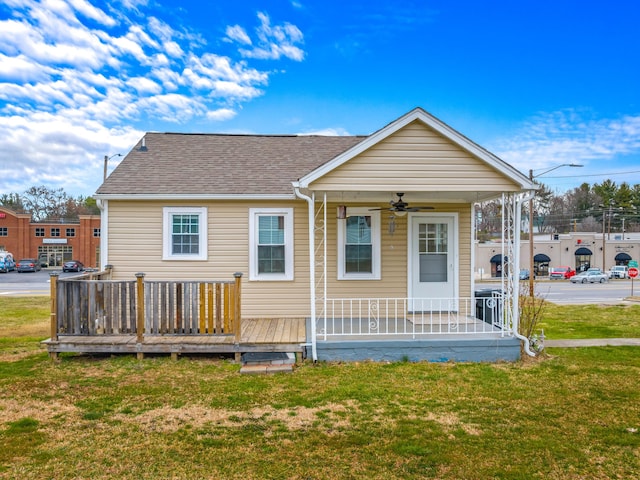 exterior space featuring a porch, a lawn, roof with shingles, and ceiling fan