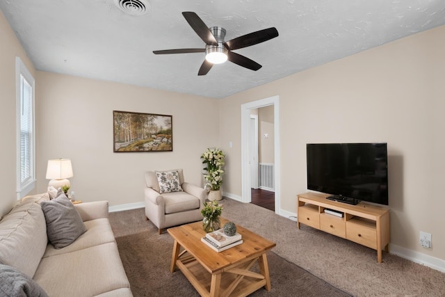 carpeted living area featuring baseboards, visible vents, and a textured ceiling