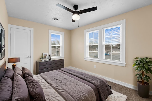 carpeted bedroom featuring visible vents, ceiling fan, a textured ceiling, and baseboards