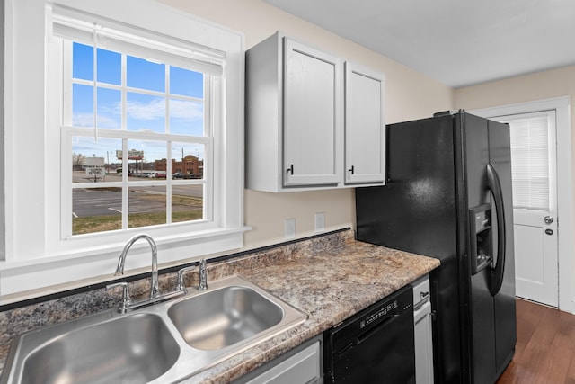 kitchen featuring a sink, black appliances, and dark wood finished floors