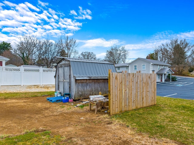 view of yard featuring an outdoor structure, fence, and a shed