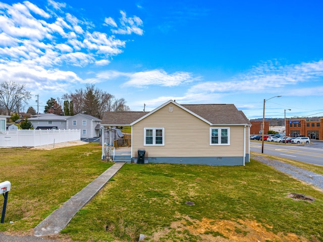 view of front of house with crawl space, a front yard, and fence