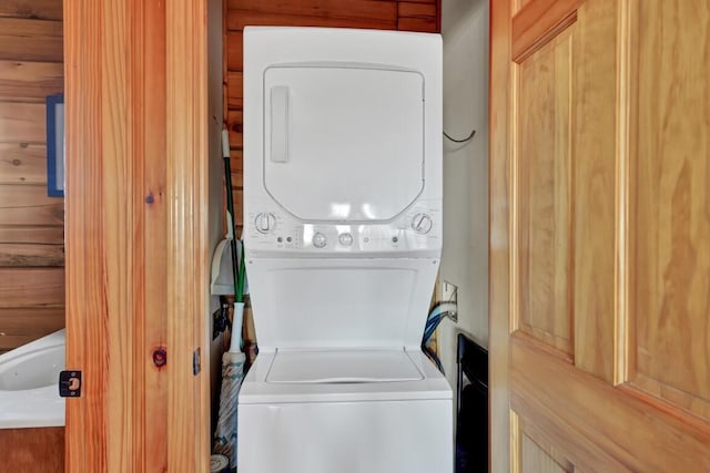 clothes washing area with stacked washer / dryer and laundry area