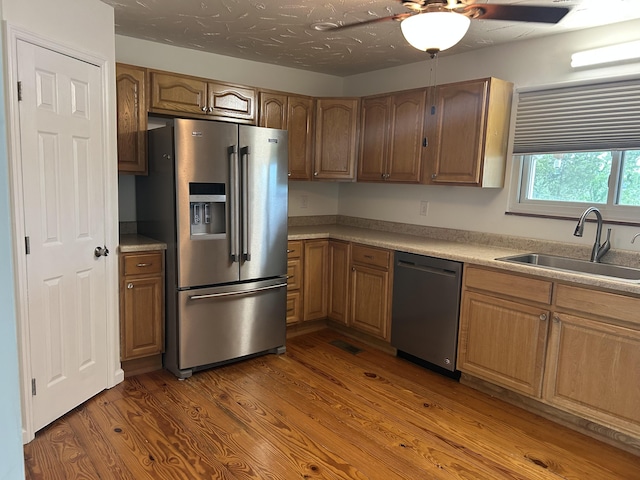 2151 Thomas Dr, Morristown, TN 37814 - kitchen with stainless steel appliances, wood finished floors, ceiling fan, light countertops, and brown cabinetry