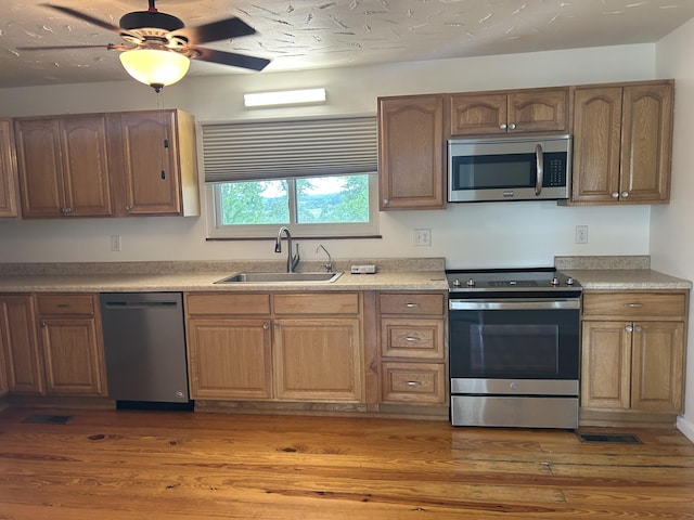 2151 Thomas Dr, Morristown, TN 37814 - kitchen featuring appliances with stainless steel finishes, light wood-style floors, ceiling fan, and light countertops