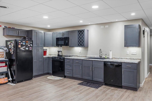 419 Colonial St, Jefferson City, TN 37760 - kitchen with black appliances, a sink, light wood-style floors, a paneled ceiling, and light stone countertops