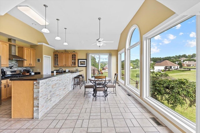 419 Colonial St, Jefferson City, TN 37760 - kitchen featuring wall chimney exhaust hood, lofted ceiling, glass insert cabinets, a ceiling fan, and dark countertops
