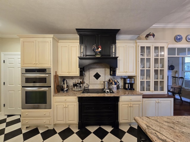 kitchen with double oven, light floors, light stone countertops, and tasteful backsplash