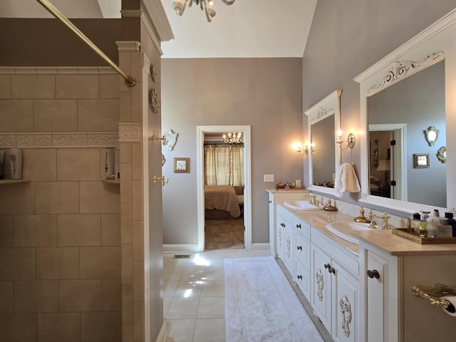 ensuite bathroom featuring tile patterned flooring, a sink, connected bathroom, and double vanity