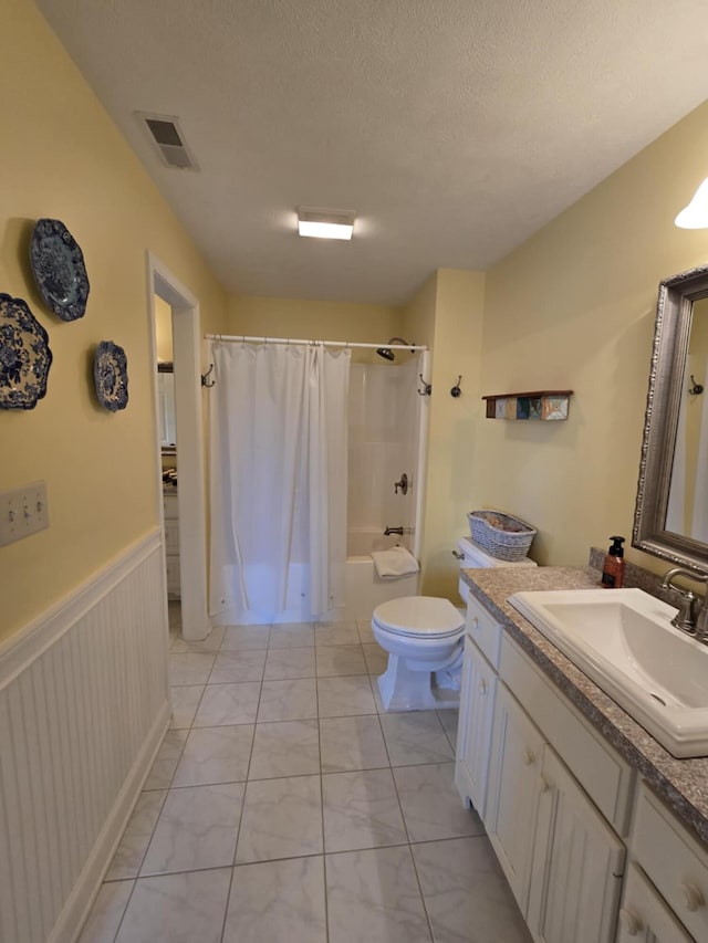 bathroom with shower / tub combo with curtain, vanity, toilet, a wainscoted wall, and visible vents