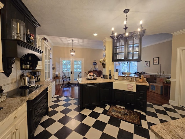 kitchen with an inviting chandelier, a sink, light floors, and dark cabinets