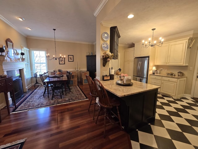 kitchen with freestanding refrigerator, white cabinets, and a chandelier