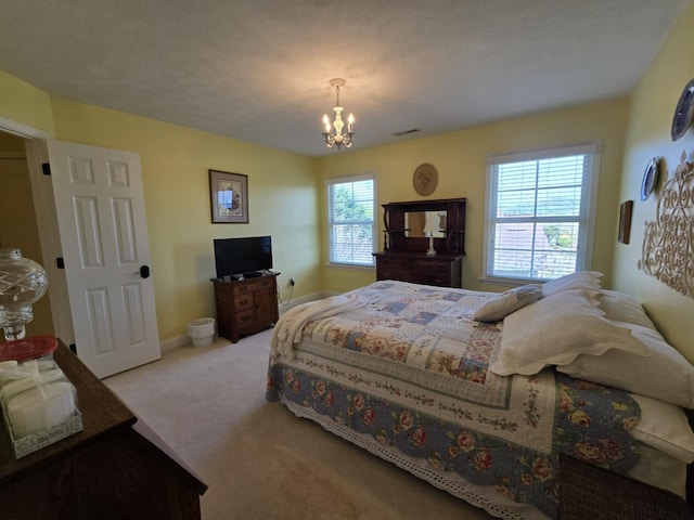 carpeted bedroom featuring an inviting chandelier, baseboards, and visible vents