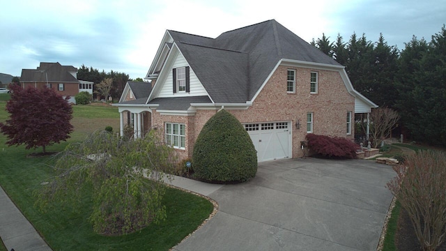 view of home's exterior with a garage, a shingled roof, driveway, and brick siding