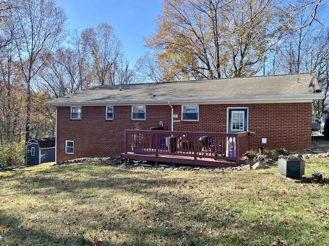 rear view of property featuring a lawn, a shed, and a wooden deck