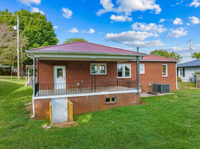 rear view of property featuring cooling unit and a yard