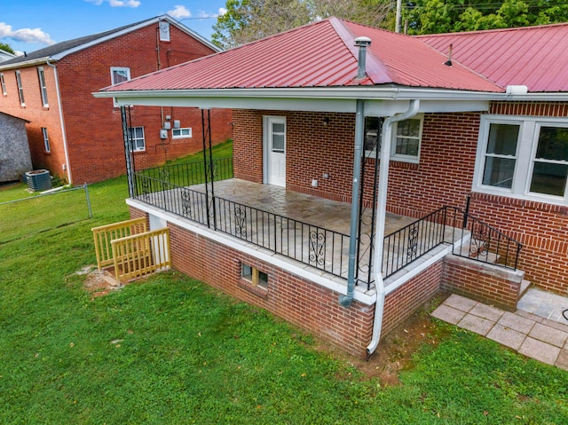 back of property featuring a yard and central air condition unit