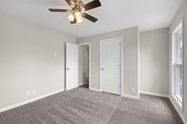 unfurnished bedroom featuring carpet flooring, multiple windows, and ceiling fan