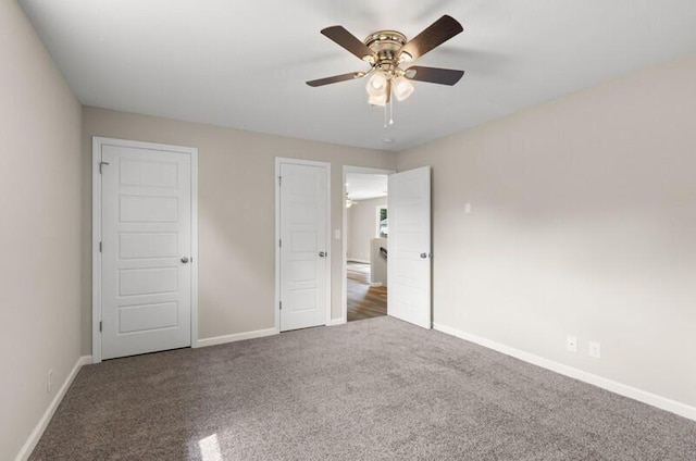 unfurnished bedroom featuring dark colored carpet and ceiling fan