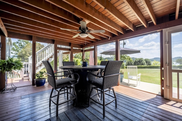 sunroom / solarium with beam ceiling, ceiling fan, and wooden ceiling