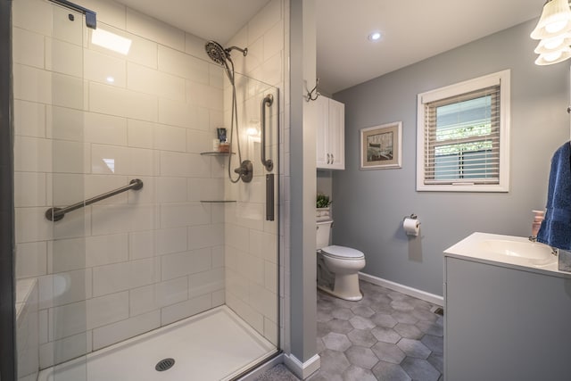 bathroom with vanity, toilet, and a shower with door