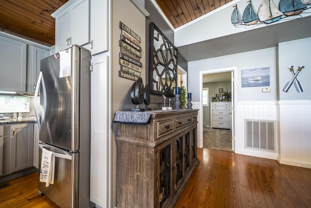 kitchen featuring white cabinets, stainless steel fridge, wooden ceiling, and dark wood-type flooring