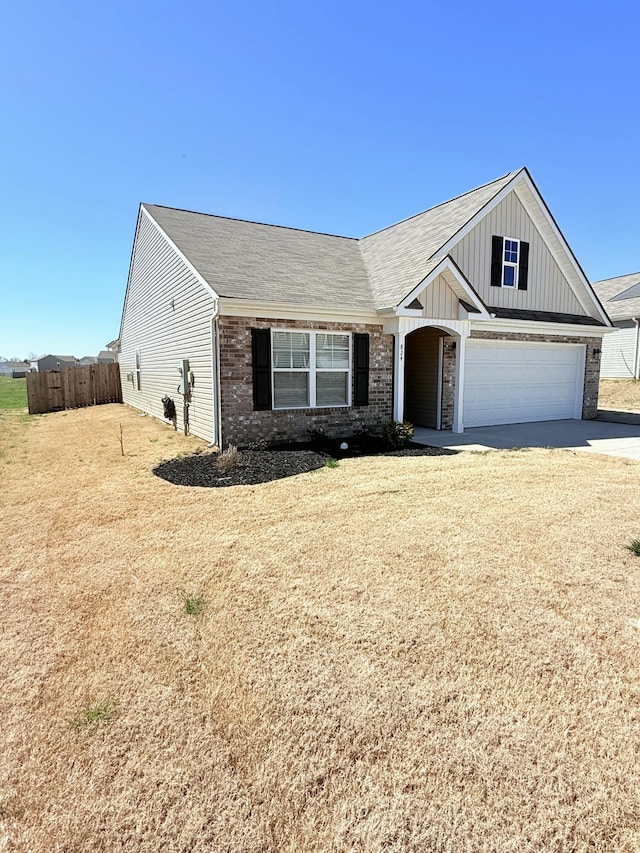 view of front of house with brick siding, fence, board and batten siding, and driveway