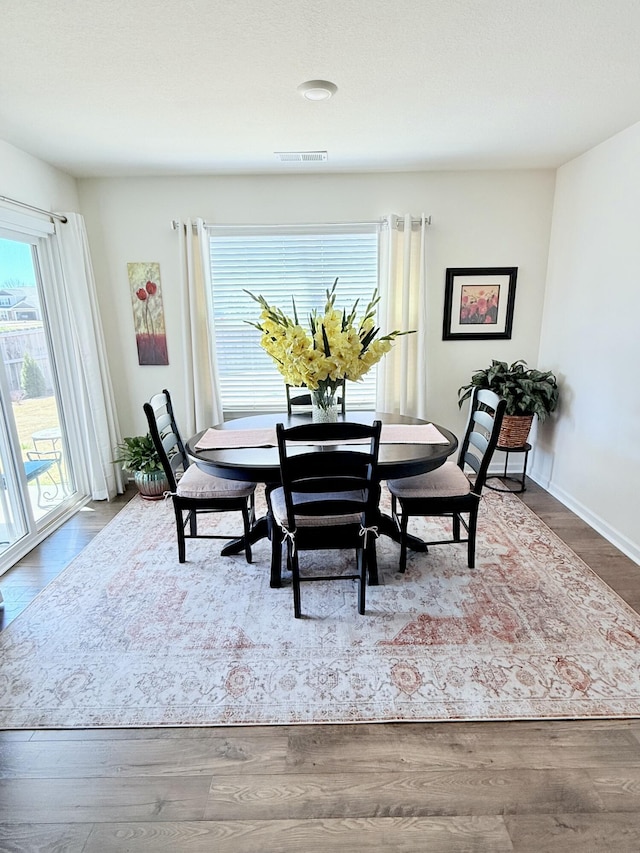 dining area featuring wood finished floors and visible vents