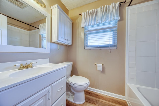 full bathroom featuring baseboards, toilet, vanity, wood finished floors, and a textured ceiling