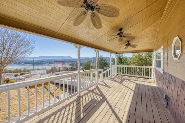 deck with a water and mountain view and a ceiling fan