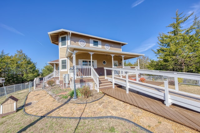 view of front of home with covered porch and fence