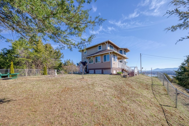 back of property featuring a yard and a fenced backyard