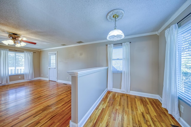 unfurnished room with ceiling fan, baseboards, crown molding, and light wood-style floors