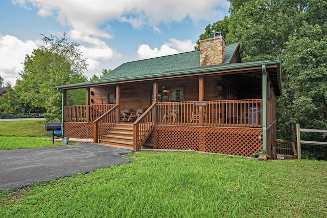 view of front of home with covered porch and a front lawn