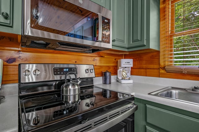 kitchen featuring sink, green cabinets, and appliances with stainless steel finishes