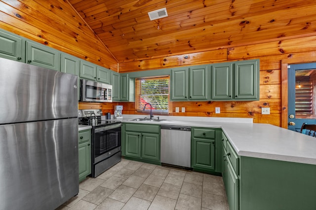 kitchen featuring lofted ceiling, sink, green cabinets, and appliances with stainless steel finishes