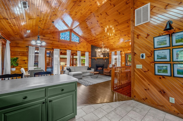 kitchen featuring pendant lighting, a notable chandelier, wood walls, and green cabinets