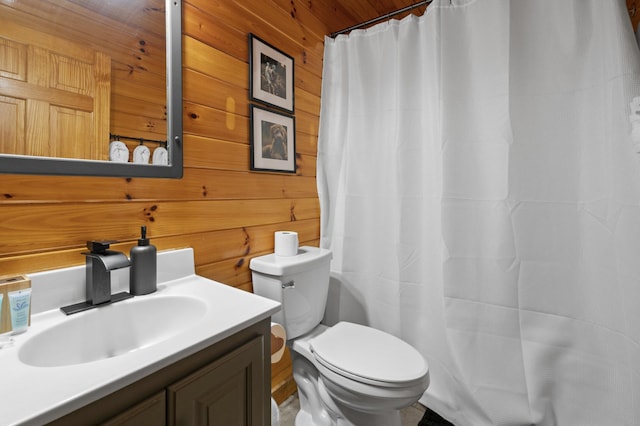 bathroom with vanity, toilet, and wood walls