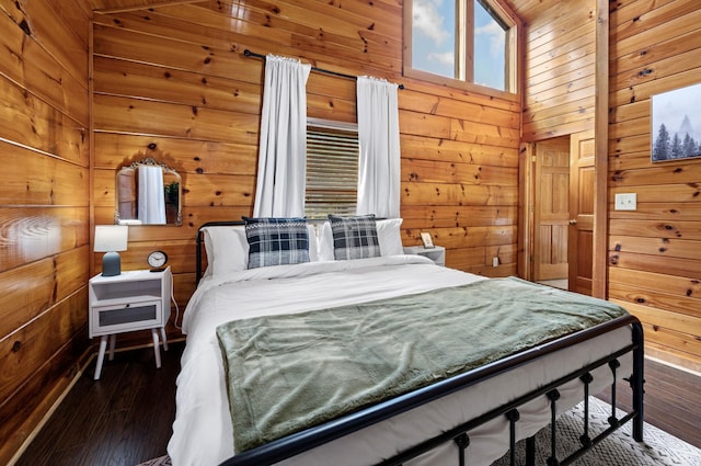 bedroom featuring a towering ceiling, dark hardwood / wood-style floors, and wood walls