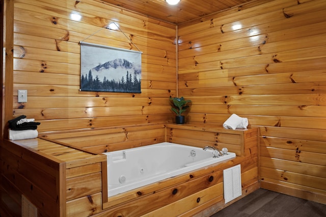 bathroom with a bath, wood-type flooring, and wood walls