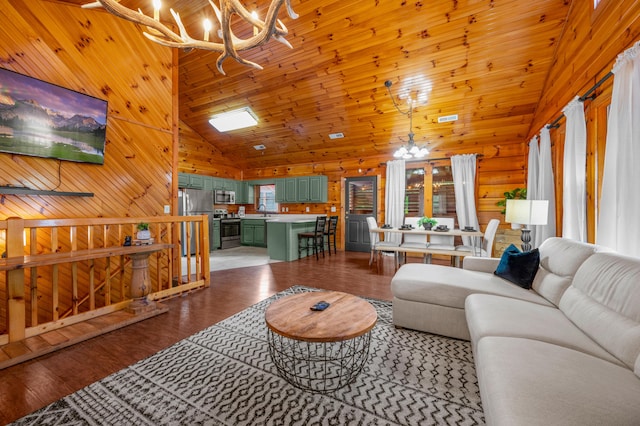 living room with sink, wood walls, high vaulted ceiling, a notable chandelier, and hardwood / wood-style floors