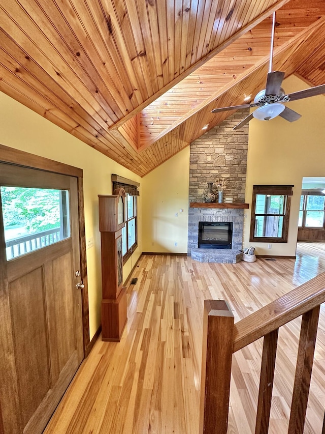 unfurnished living room featuring ceiling fan, wooden ceiling, high vaulted ceiling, light hardwood / wood-style floors, and a fireplace