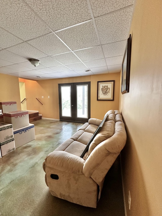 living room with a drop ceiling and french doors