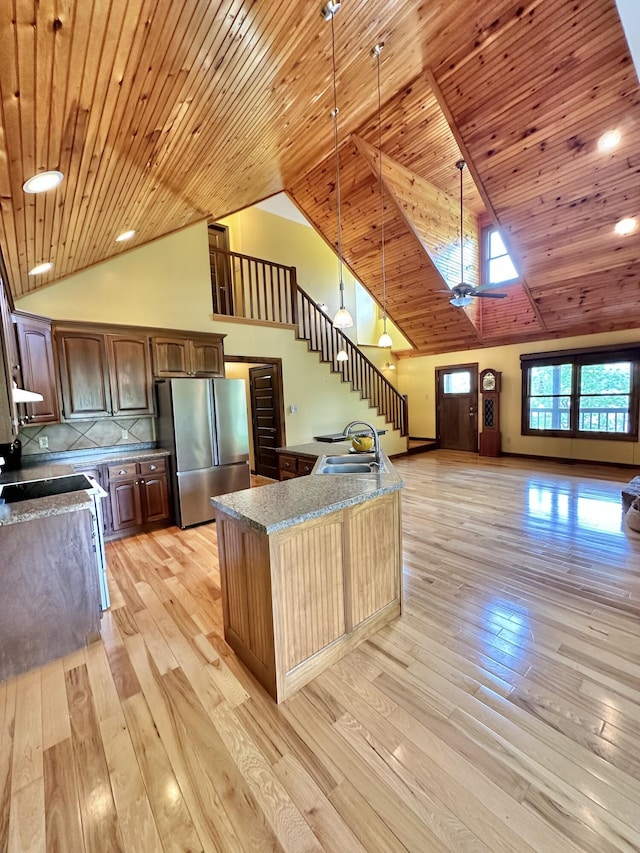 kitchen featuring light hardwood / wood-style flooring, high vaulted ceiling, stainless steel fridge, pendant lighting, and wood ceiling