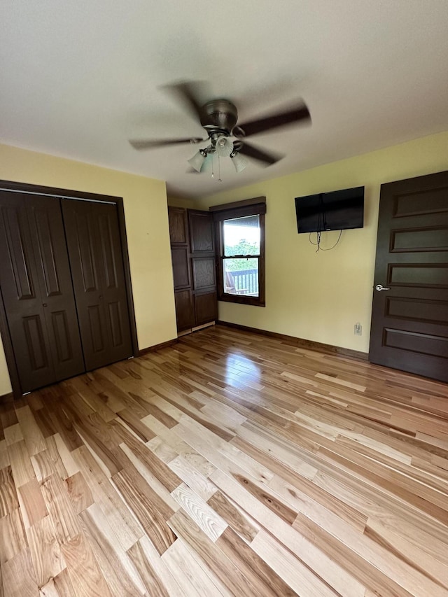 unfurnished bedroom featuring a closet, light hardwood / wood-style flooring, and ceiling fan