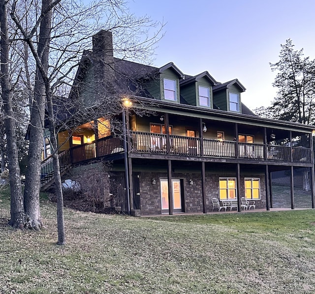 rear view of house featuring a lawn and a wooden deck