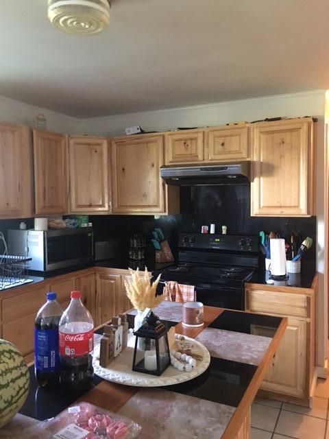 kitchen featuring light tile patterned floors and black electric range