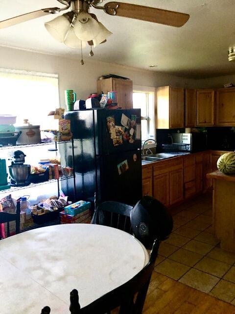 kitchen with black refrigerator, tile patterned floors, and sink